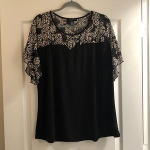 Black stretchy material tee with faux sheer embroidery.